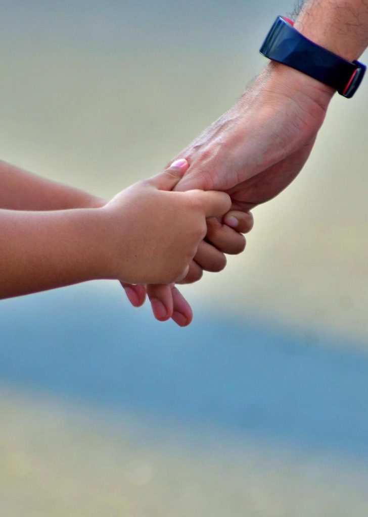 photo of child and child holding hands