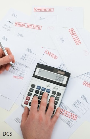 photo showing calculator on top of overdue invoices